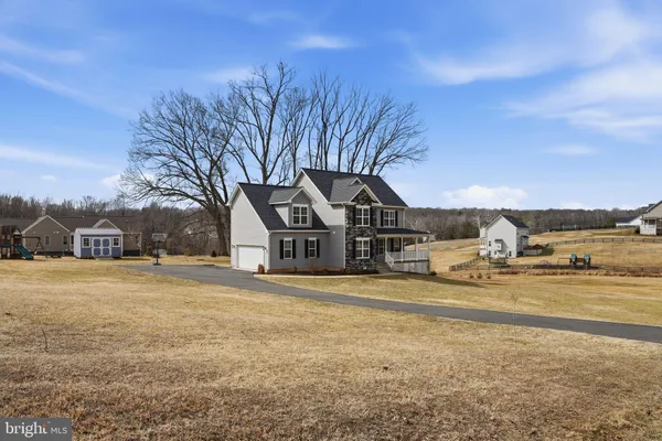 a front view of a house with a yard and mountain view