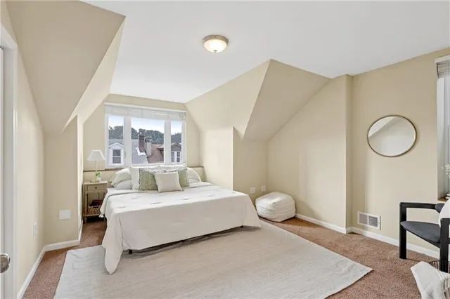 a bedroom with a large bed and a mirror