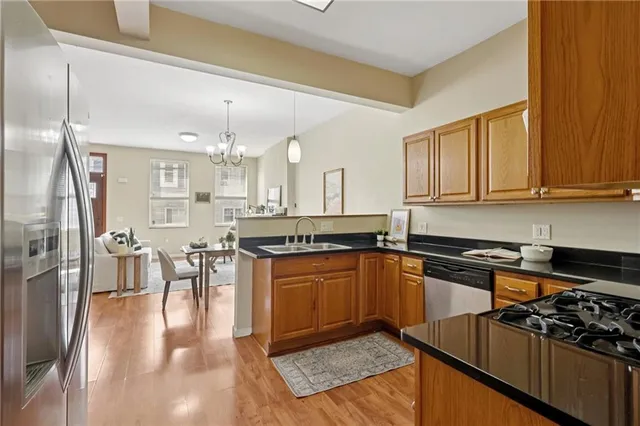 a kitchen with stainless steel appliances granite countertop a sink stove and refrigerator