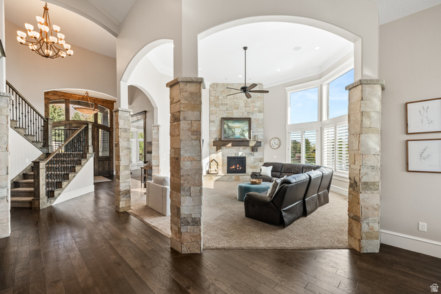 1205 North Elk Rdg Lane, Unit 202 Alpine, UT 84004 - Photo 16 of 88 Expansive living area with wood-finish flooring, stone-clad archways, and a multi-level staircase with wrought iron balusters