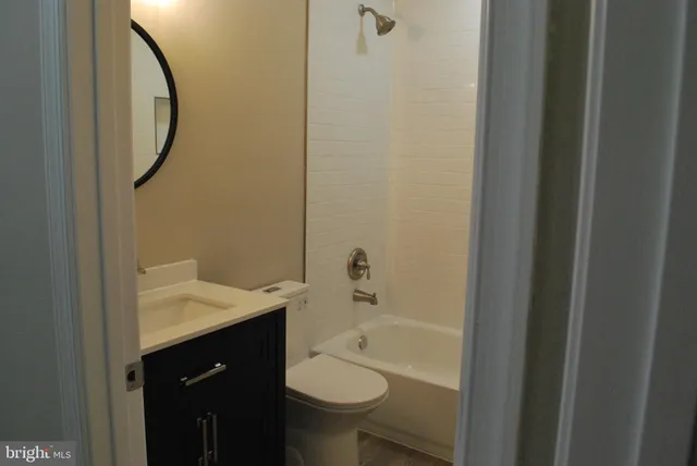 a view of an empty room with wooden floor and closet