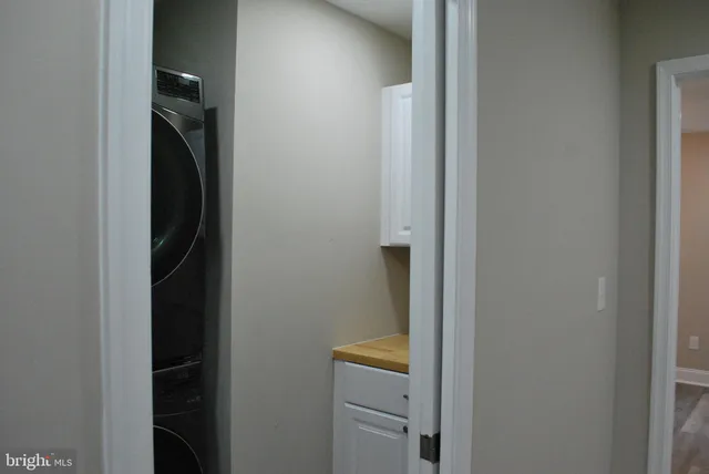 an empty room with wooden floor chandelier fan and windows