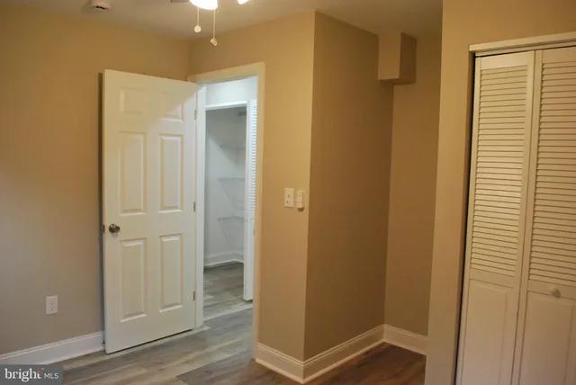 a bathroom with a granite countertop toilet a sink and a mirror