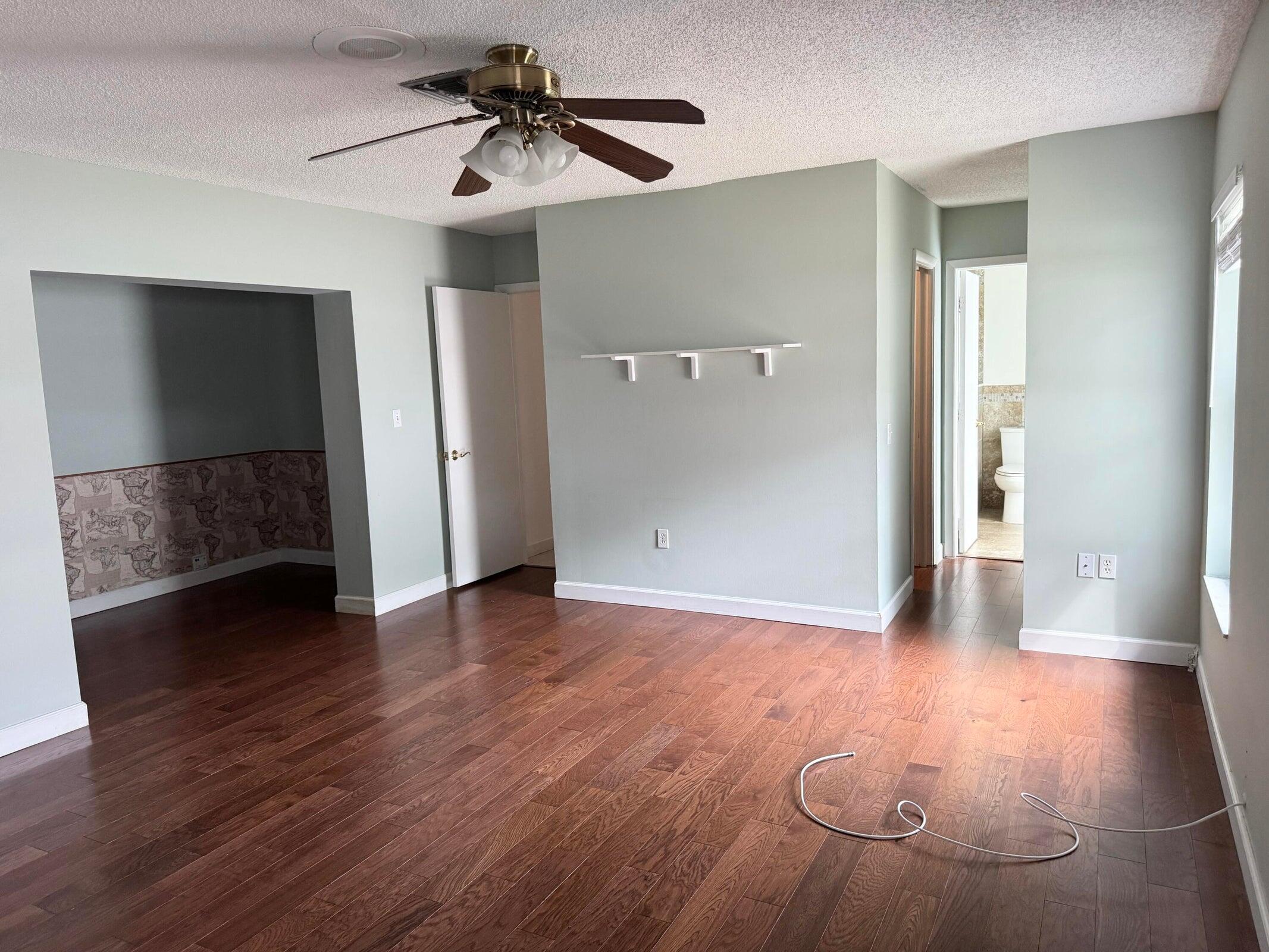 23261 Boca Club Colony Circle Boca Raton, FL 33433 - Photo 12 of 17 a view of a livingroom with wooden floor and a ceiling fan
