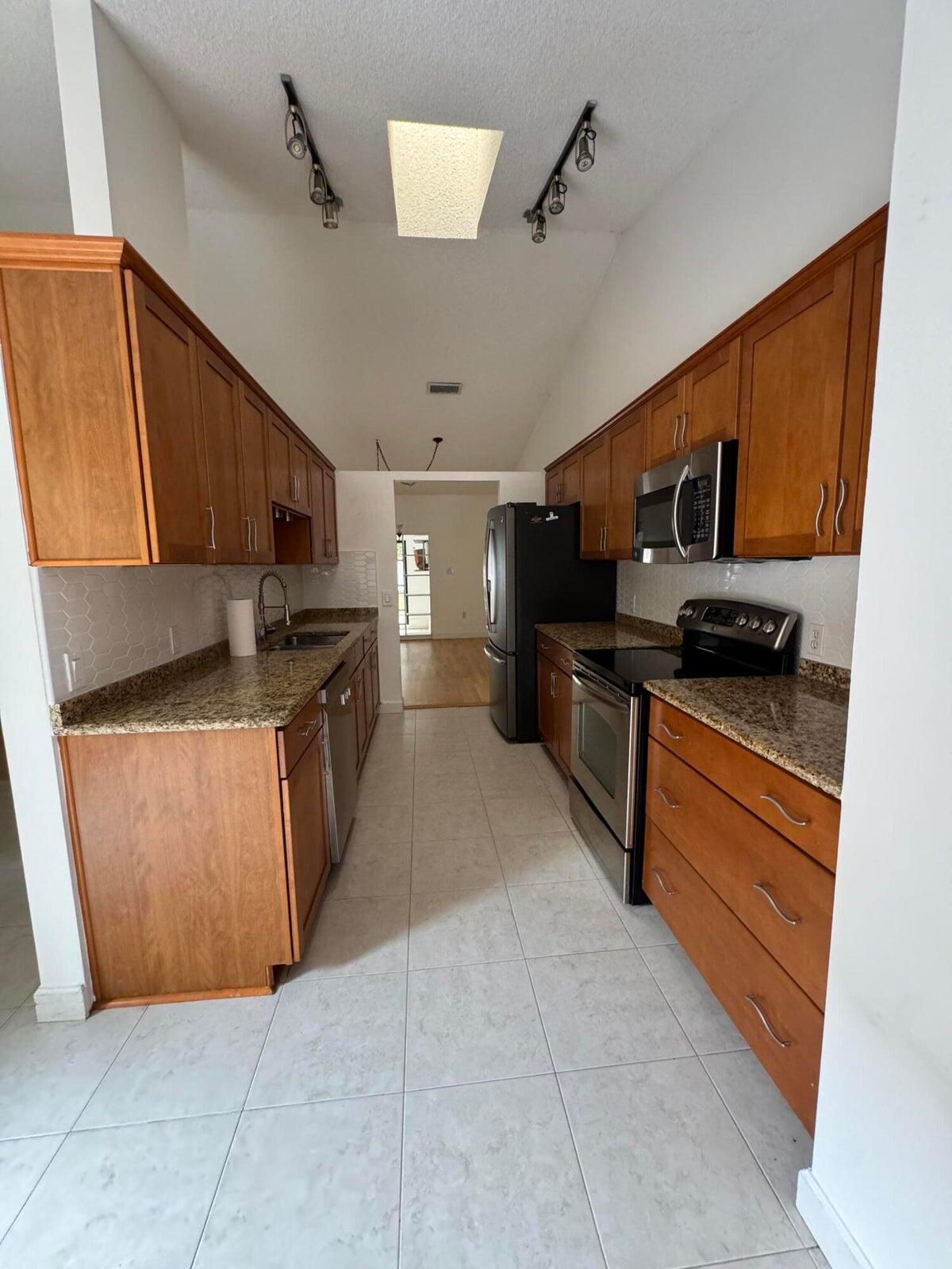 23261 Boca Club Colony Circle Boca Raton, FL 33433 - Photo 15 of 17 a kitchen with stainless steel appliances granite countertop a stove a sink and a refrigerator