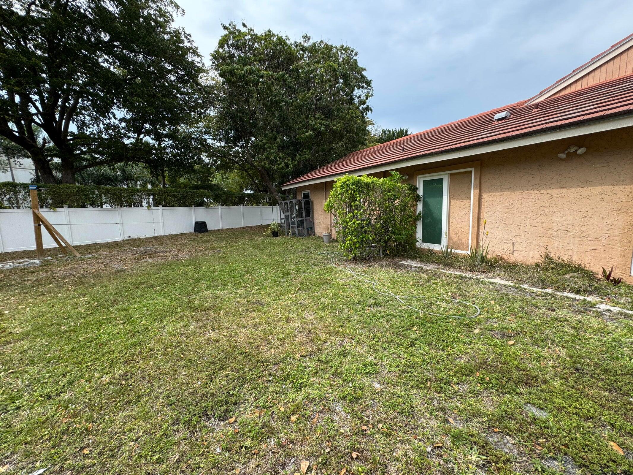 23261 Boca Club Colony Circle Boca Raton, FL 33433 - Photo 3 of 17 a backyard of a house with large trees and plants