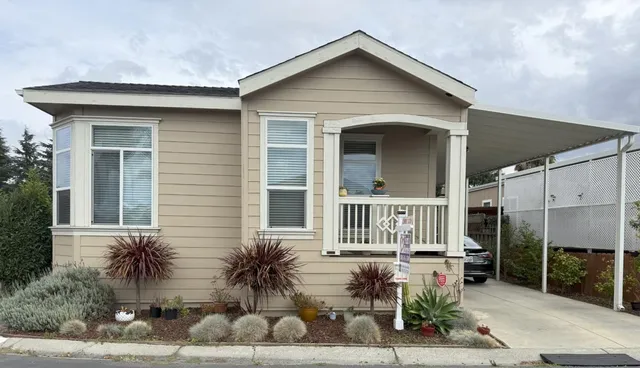 a view of a house with a yard and potted plants