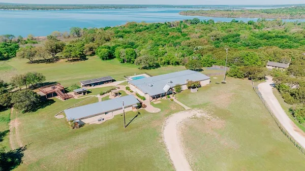 an aerial view of a house with a garden and lake view