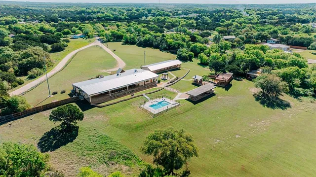 an aerial view of a house with swimming pool lawn chairs and a yard