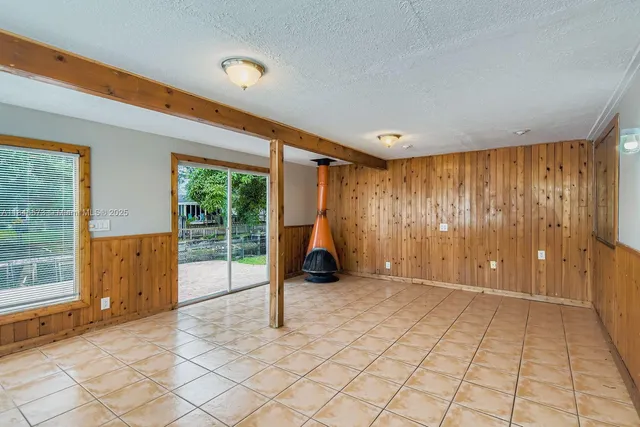 a view of a room with a large window and hardwood