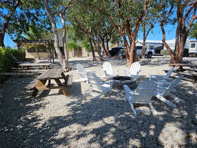 a view of a backyard with table and chairs and a fire pit