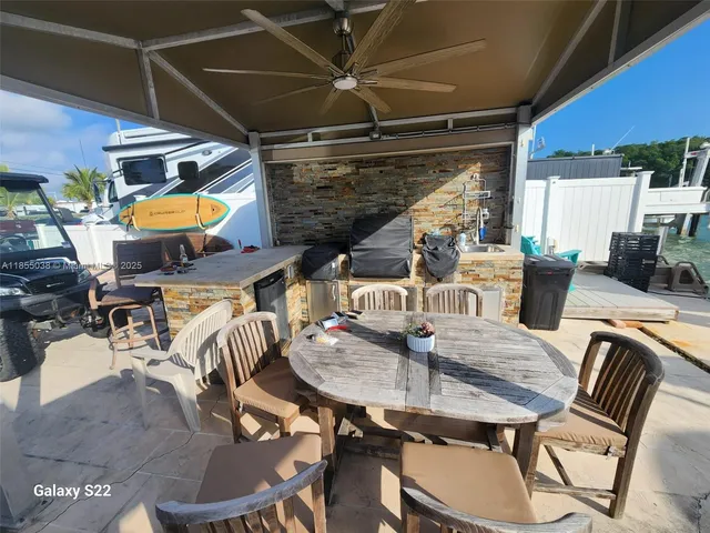 a view of a patio with table and chairs a barbeque