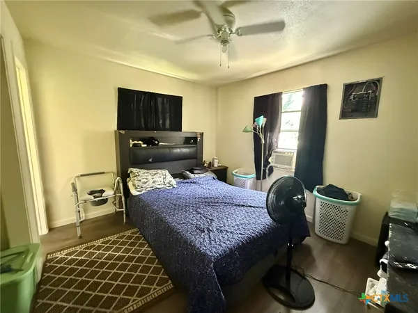 a bedroom with a bed and wooden floor