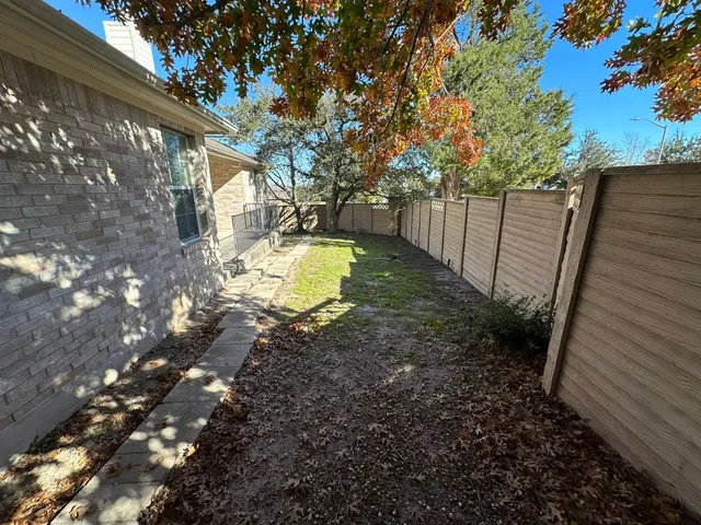a view of backyard with wooden fence