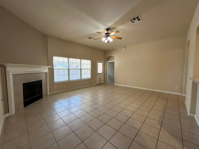 a view of an empty room with a fireplace and a window