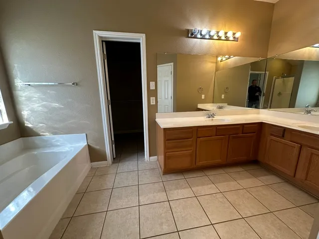 a large bathroom with a large tub and sink