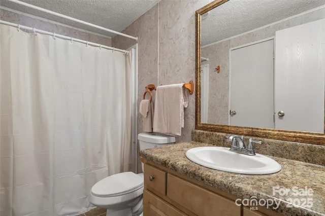 a bathroom with a granite countertop sink toilet and a mirror