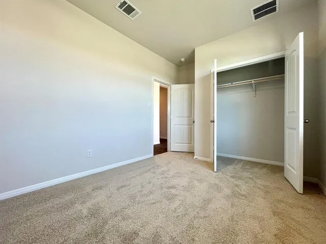an empty room with closet and a bathroom