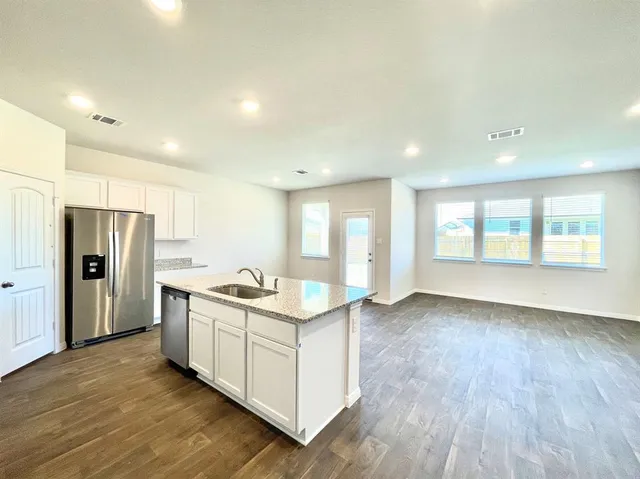 a kitchen with stainless steel appliances granite countertop a stove and a refrigerator