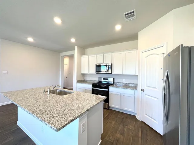 a kitchen with stainless steel appliances granite countertop a sink stove and refrigerator