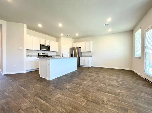 a view of kitchen with microwave oven stove and cabinets