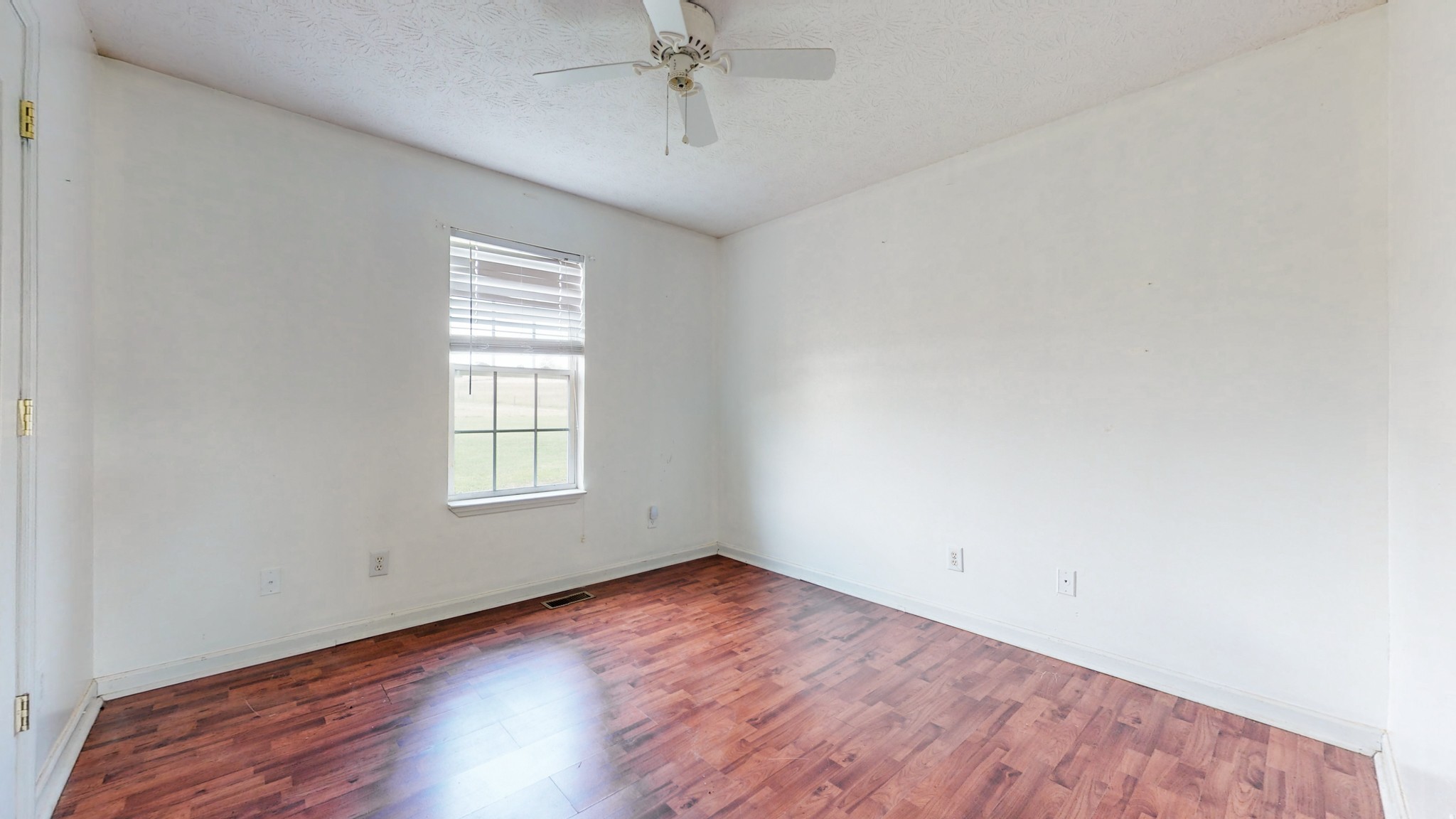 643 Beech Log Road Watertown, TN 37184 - Photo 13 of 31 an empty room with wooden floor chandelier fan and windows