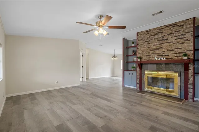 an empty room with a window and a fan
