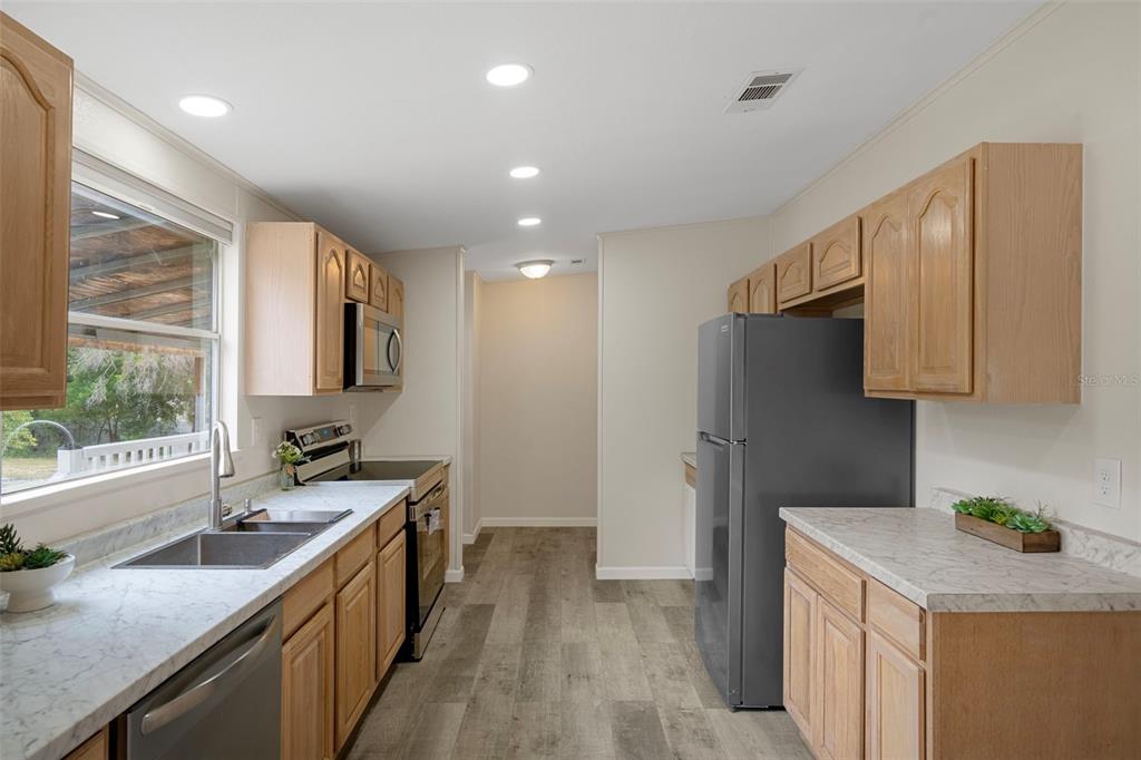 18008 Greensboro Street Spring Hill, FL 34610 - Photo 22 of 49 a kitchen with a sink a refrigerator and a stove top oven