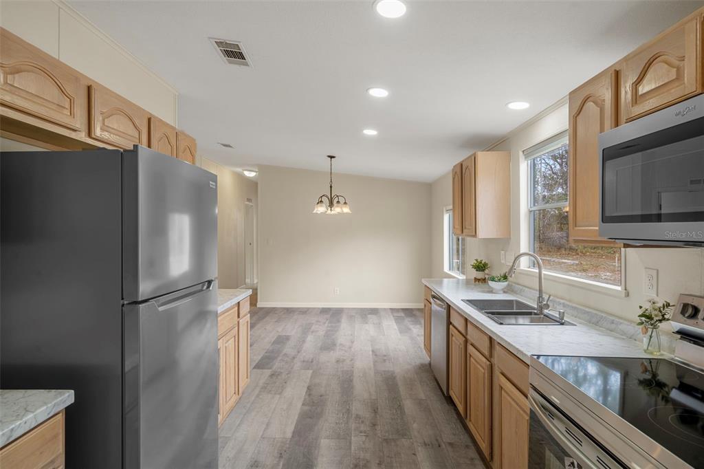 18008 Greensboro Street Spring Hill, FL 34610 - Photo 24 of 49 a kitchen with stainless steel appliances granite countertop a refrigerator a sink and a stove