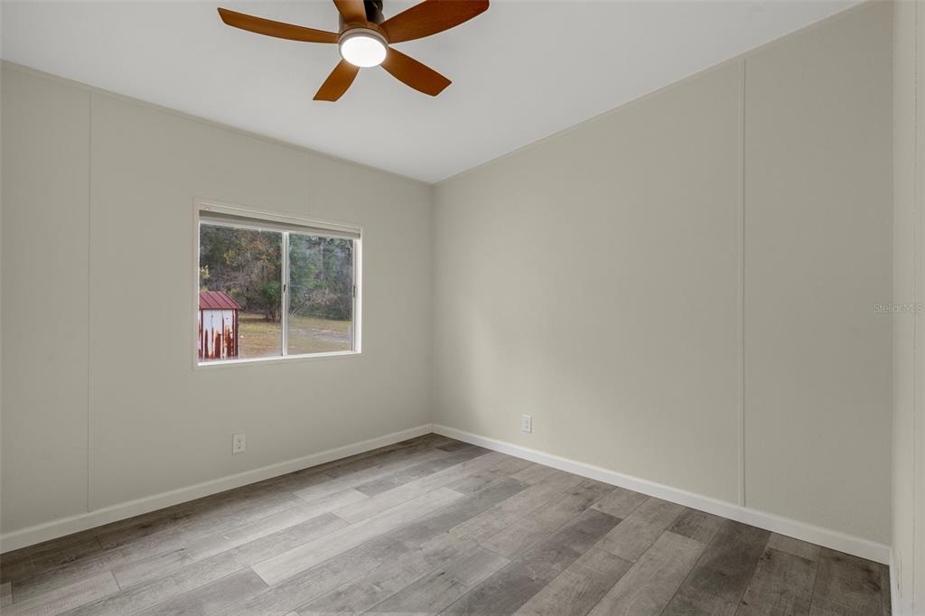 18008 Greensboro Street Spring Hill, FL 34610 - Photo 38 of 49 an empty room with a window and a ceiling fan