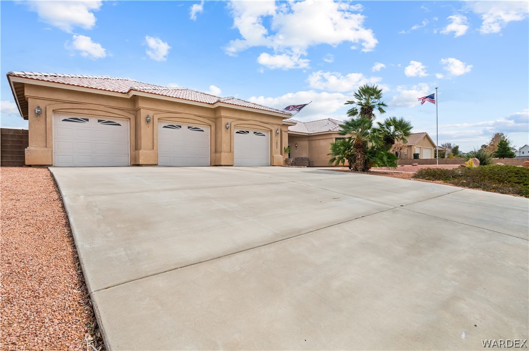 2898 Mountain Trail Road Kingman, AZ 86401 - Photo 36 of 75 a front view of a house with a yard and garage
