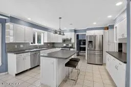 a kitchen with stainless steel appliances kitchen island granite countertop a sink and cabinets