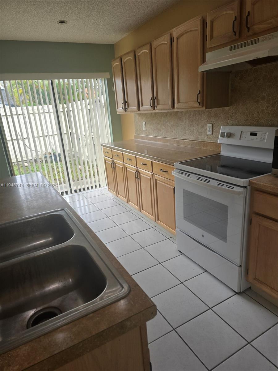 1322 Sandpiper Boulevard, Unit 1 Homestead, FL 33034 - Photo 15 of 25 a kitchen with granite countertop a stove and a sink