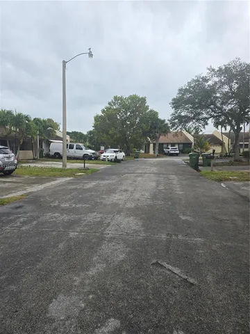 a view of a field with cars parked in front of it