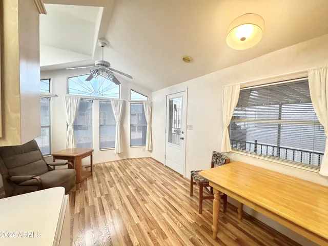 a kitchen that has a stove a sink dishwasher a dining table and chairs with wooden floor