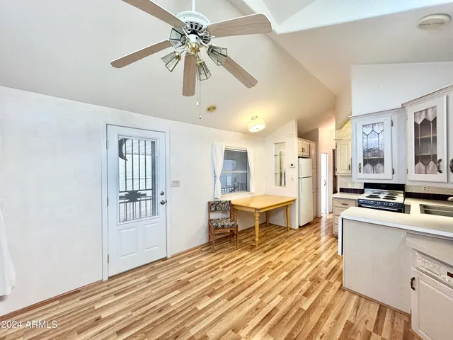 a view of a livingroom with furniture a chandelier fan and wooden floor