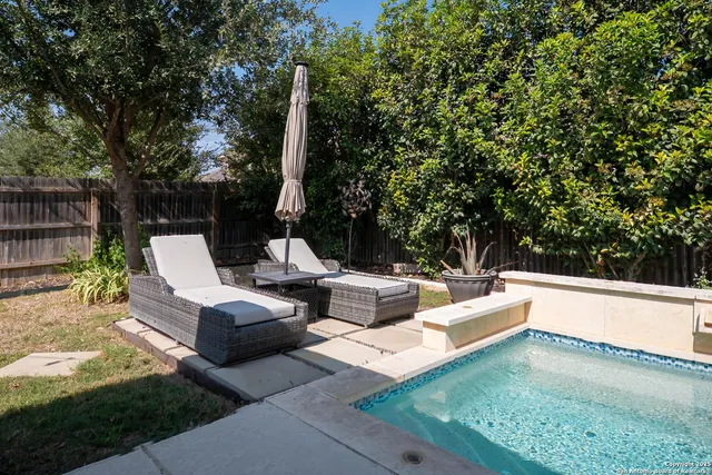 a view of a patio with couches table and chairs under an umbrella