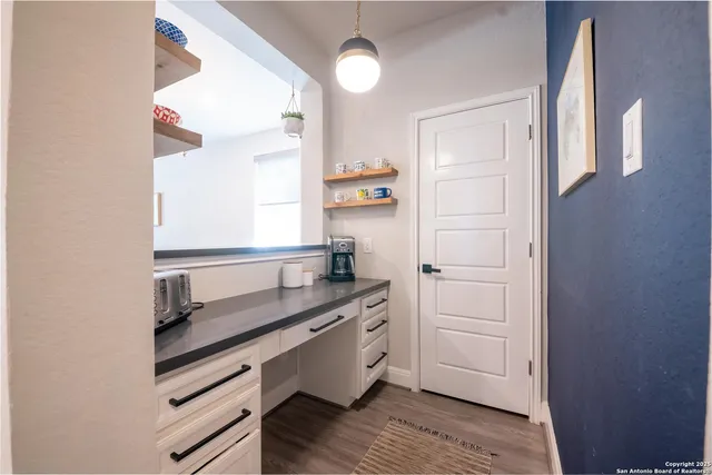 a kitchen with stainless steel appliances a dining table chairs stove and cabinets