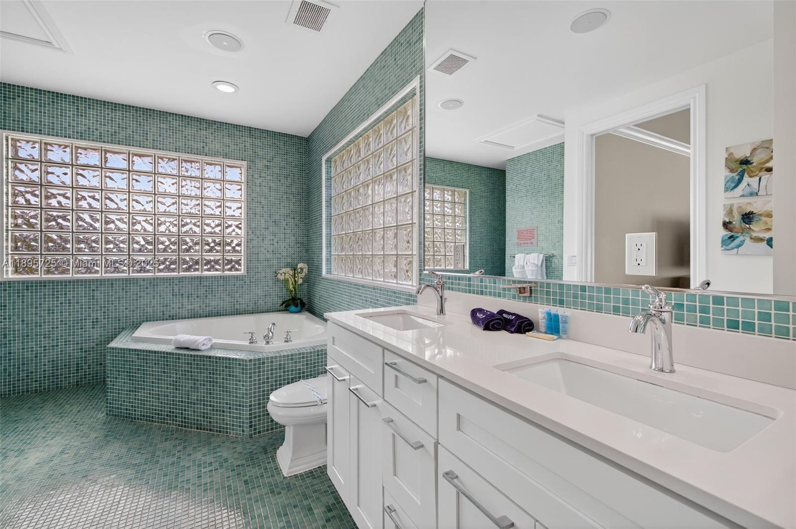 312 Northeast 12th Avenue Fort Lauderdale, FL 33301 - Photo 24 of 39 a bathroom with a double vanity sink a toilet a mirror and bathtub