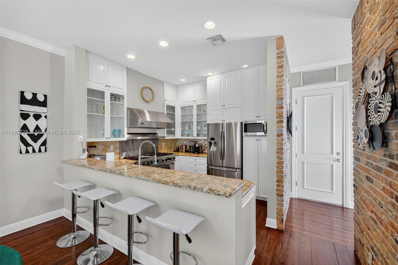 312 Northeast 12th Avenue Fort Lauderdale, FL 33301 - Photo 7 of 39 a kitchen with stainless steel appliances granite countertop a refrigerator a stove and a wooden floor