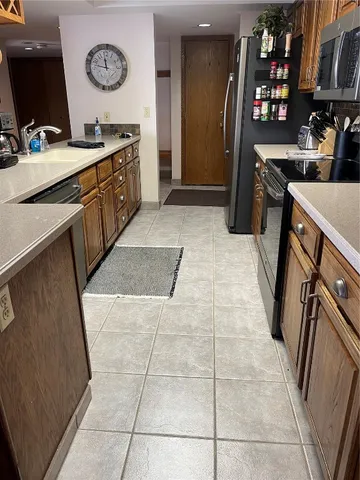 a kitchen with stainless steel appliances a stove refrigerator and a sink