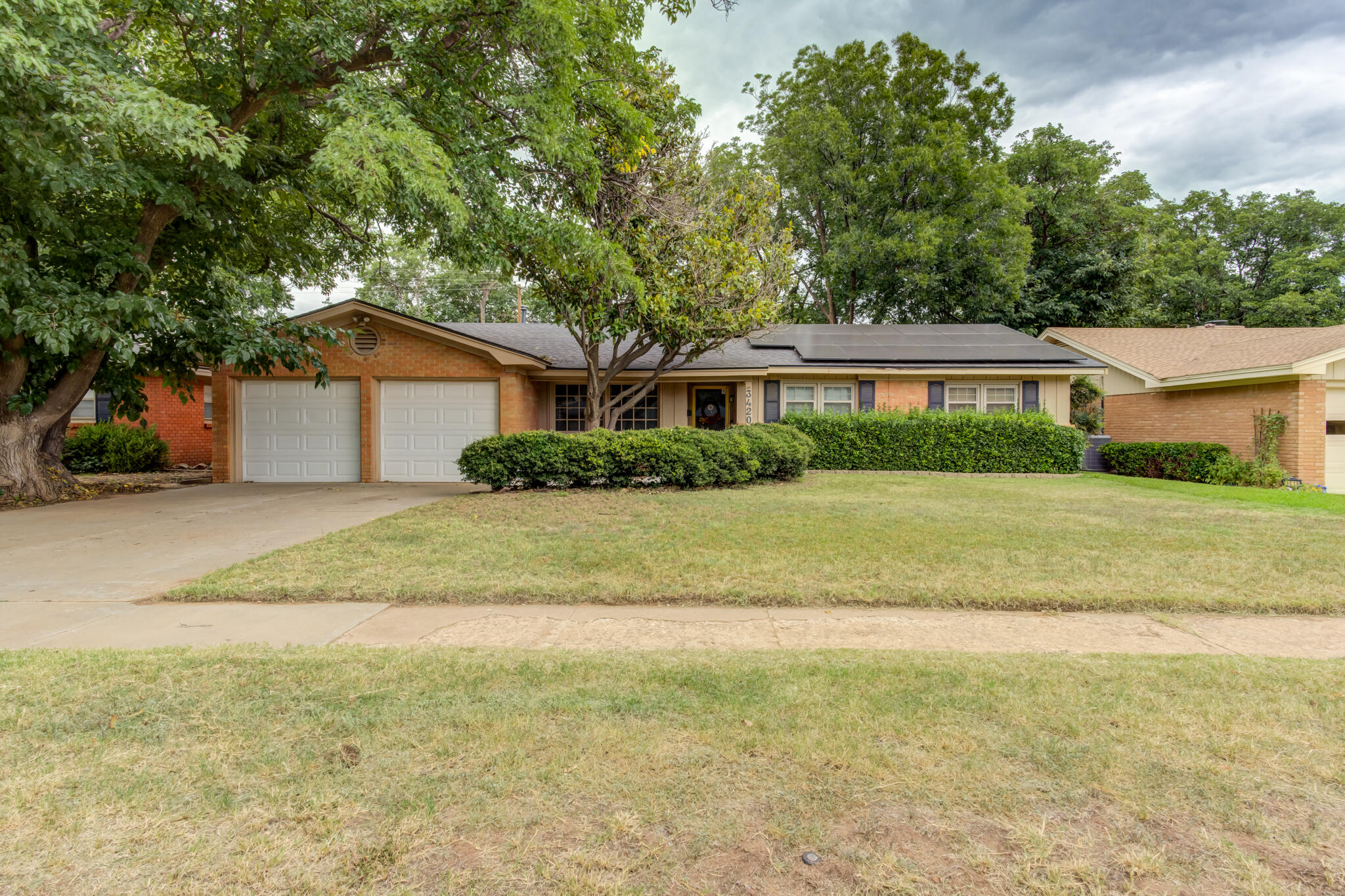 3420 60th Street Lubbock, TX 79413 - Photo 1 of 57 a front view of a house with a garden