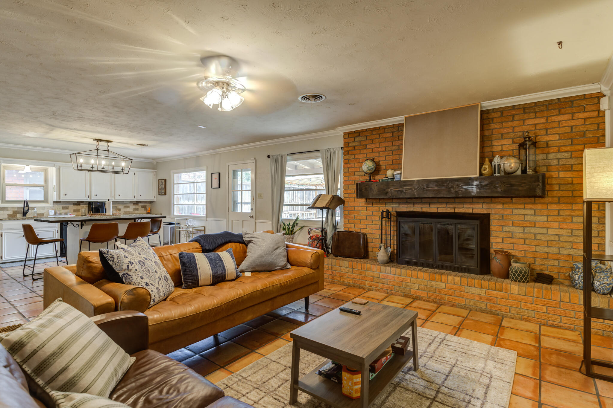 3420 60th Street Lubbock, TX 79413 - Photo 14 of 57 a living room with furniture a fireplace and a dining table with wooden floor