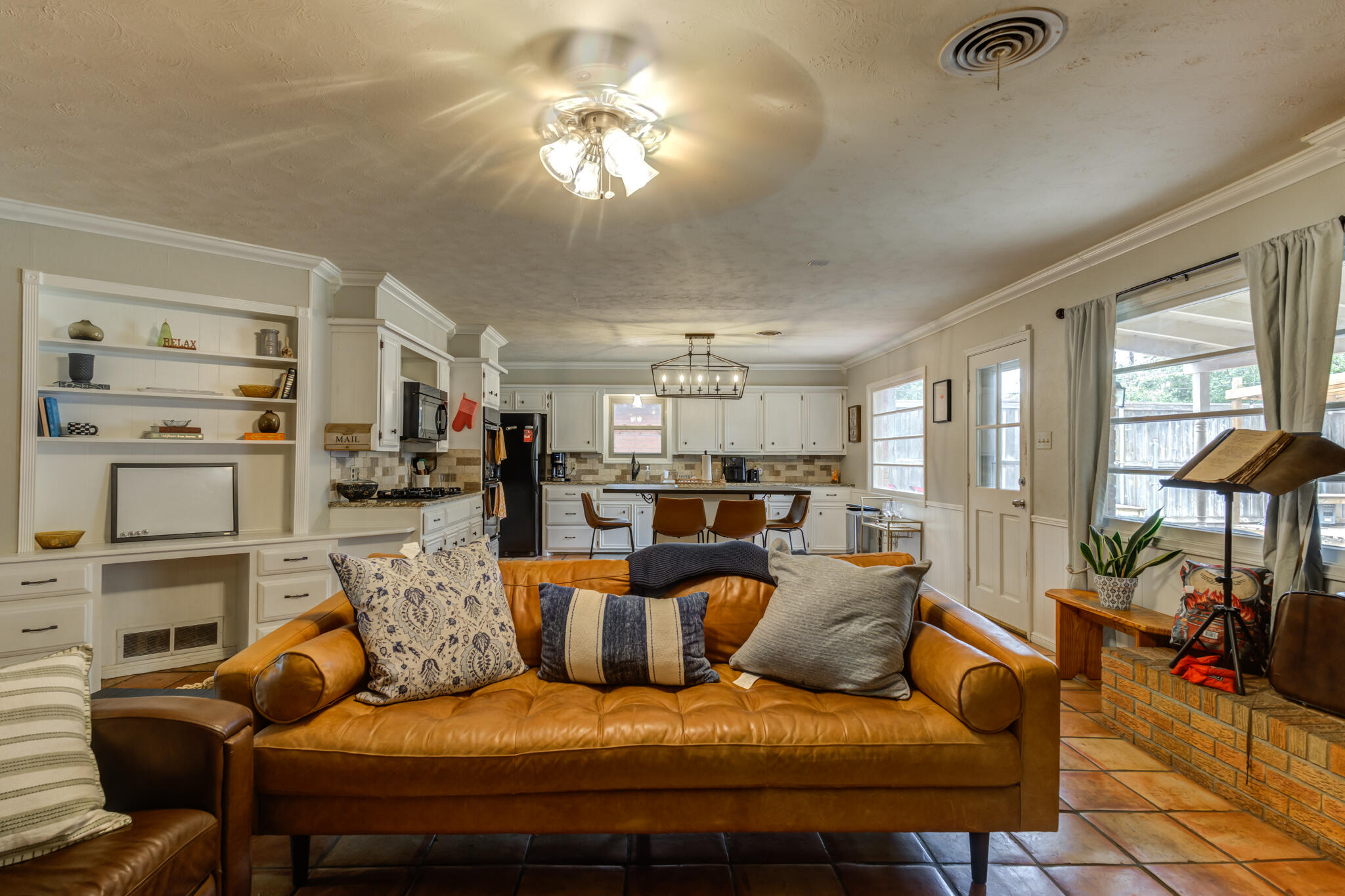 3420 60th Street Lubbock, TX 79413 - Photo 16 of 57 a living room with furniture a chandelier and kitchen view