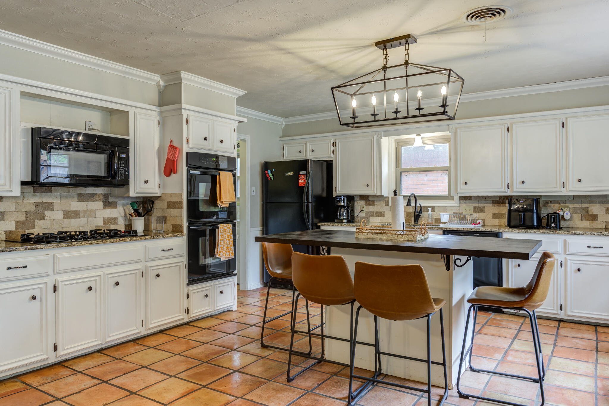 3420 60th Street Lubbock, TX 79413 - Photo 24 of 57 a kitchen with stainless steel appliances granite countertop a stove top oven a refrigerator a sink dishwasher and white cabinets with wooden floor