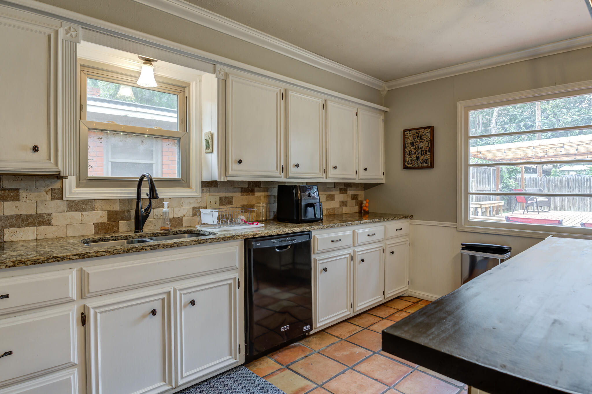 3420 60th Street Lubbock, TX 79413 - Photo 30 of 57 a kitchen with granite countertop white cabinets white appliances and a window