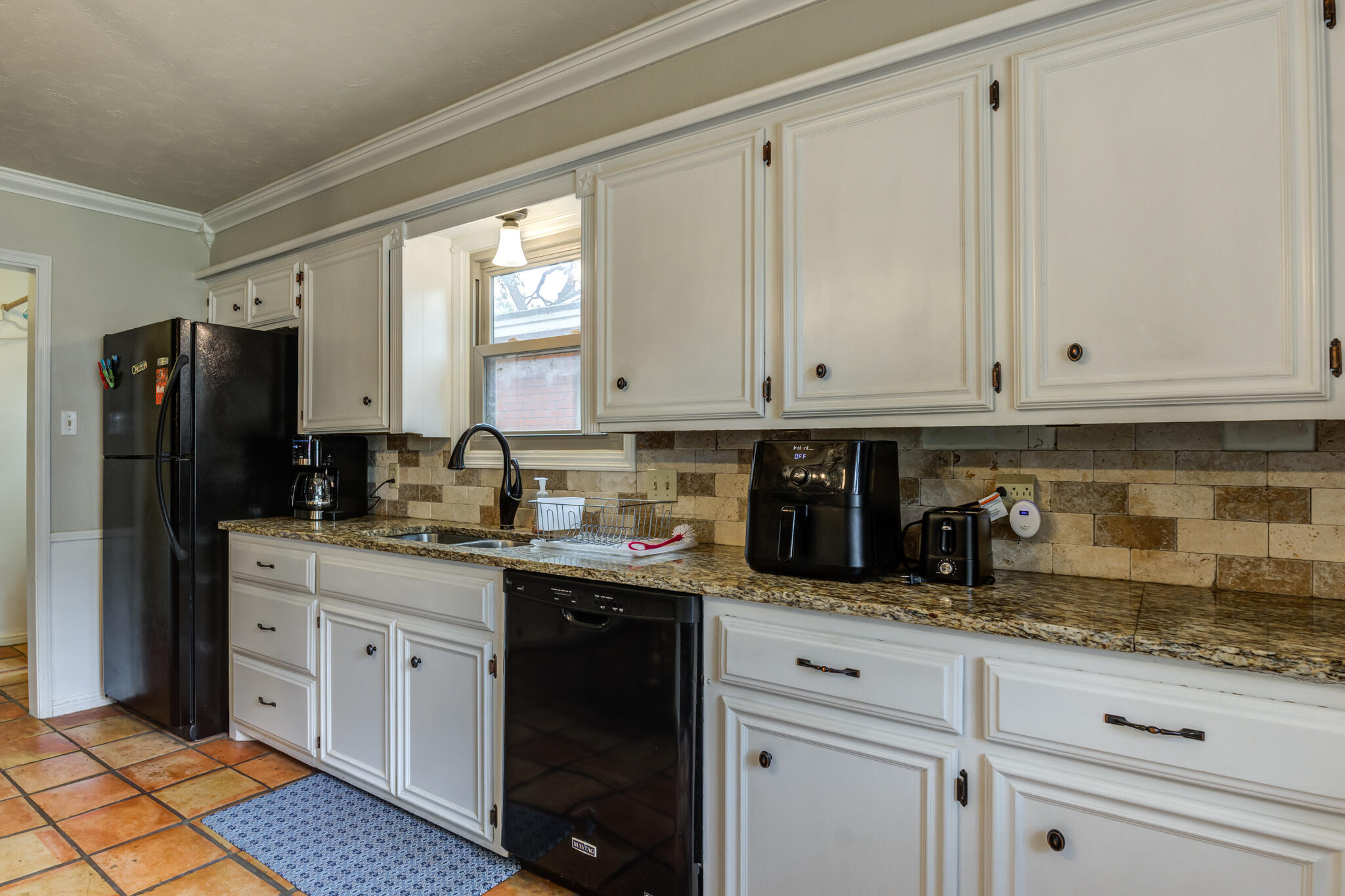 3420 60th Street Lubbock, TX 79413 - Photo 34 of 57 a kitchen with granite countertop white cabinets and refrigerator