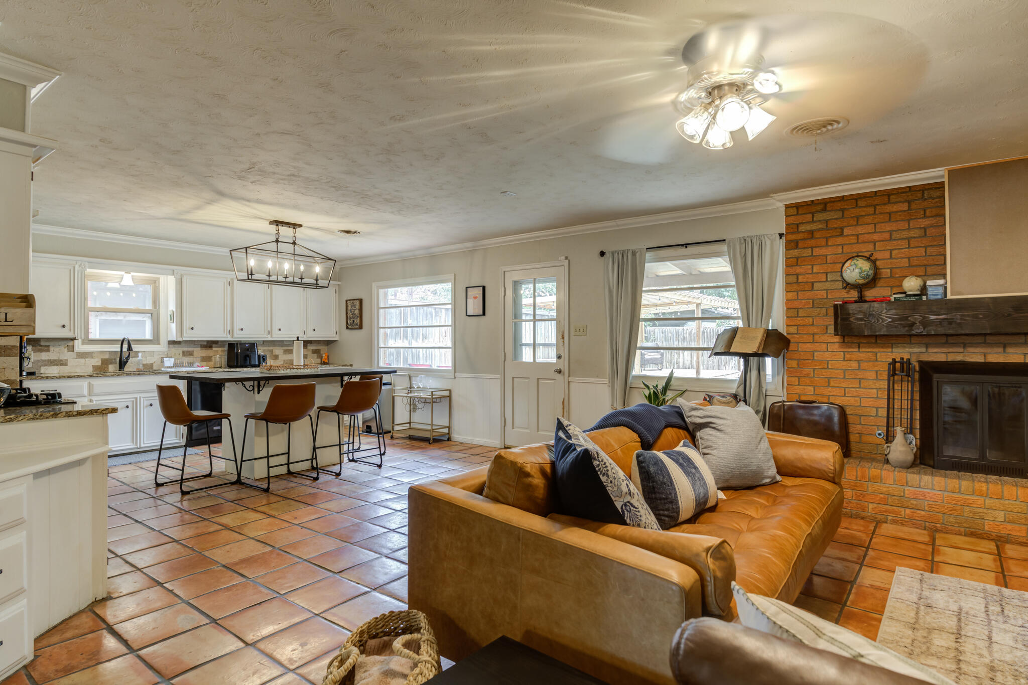3420 60th Street Lubbock, TX 79413 - Photo 38 of 57 a living room with furniture a fireplace and a dining table with kitchen view