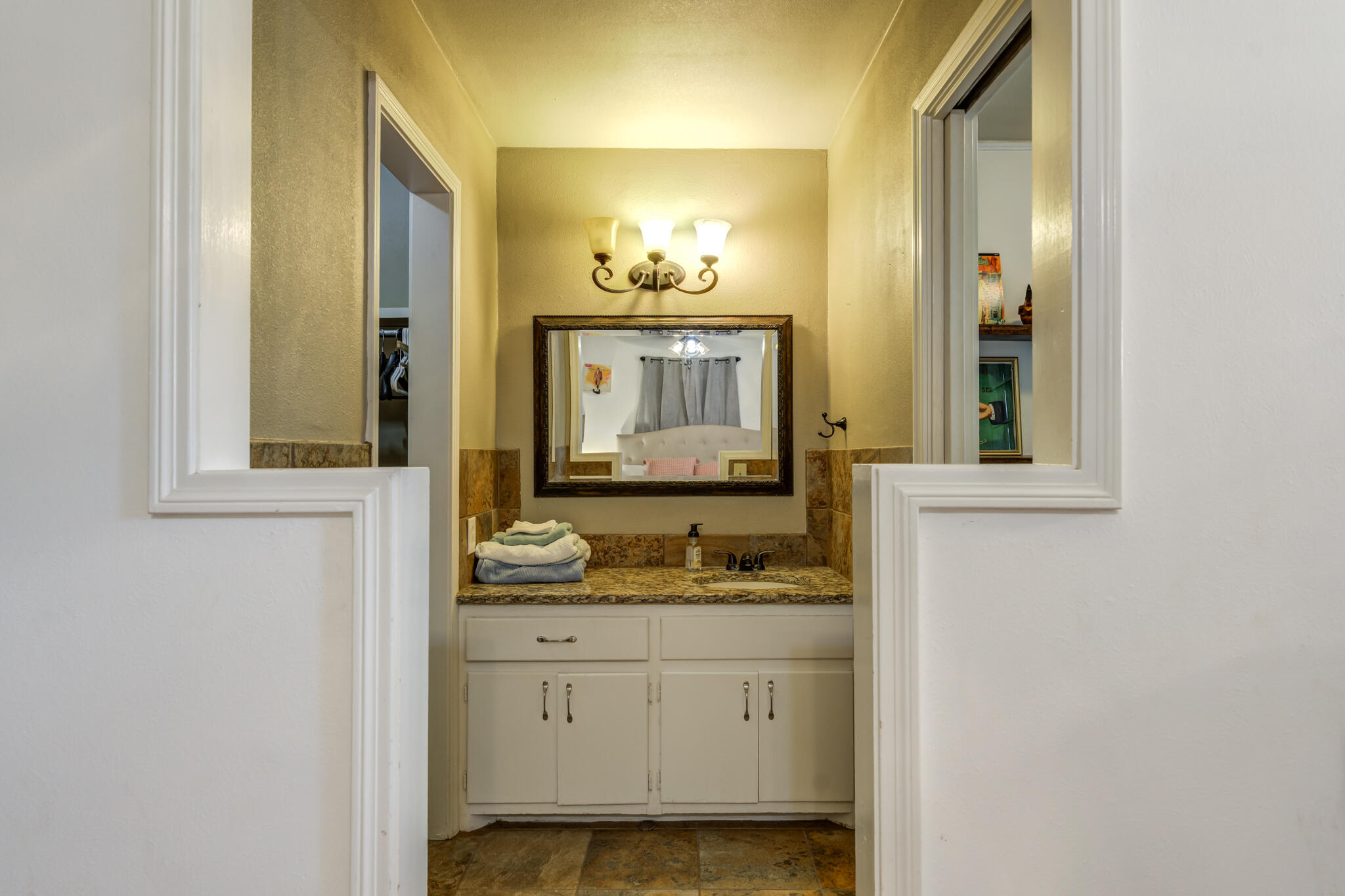 3420 60th Street Lubbock, TX 79413 - Photo 50 of 57 a bathroom with a sink and a mirror