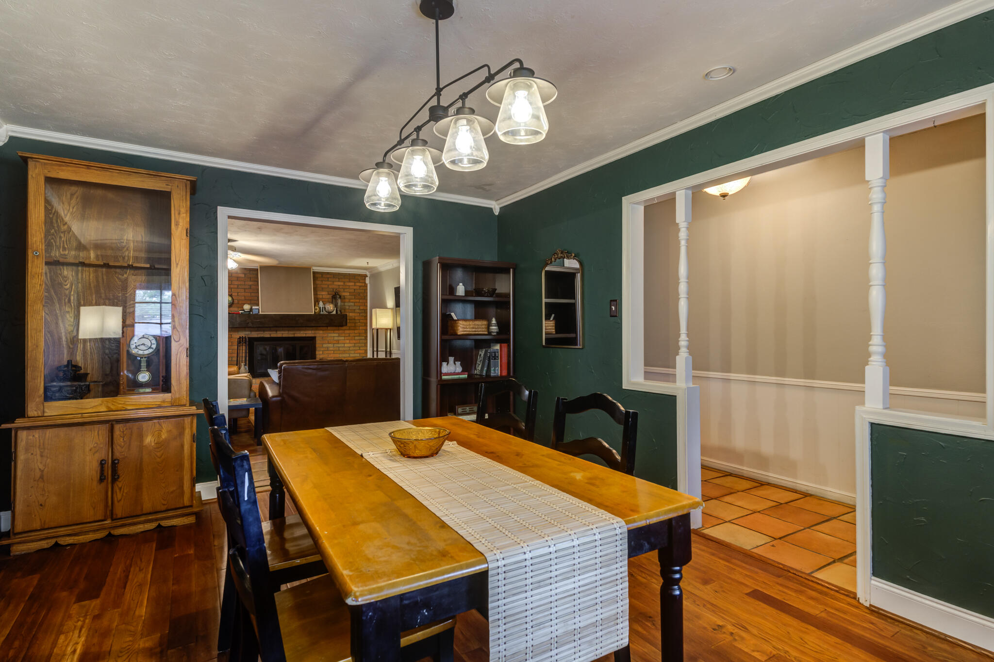 3420 60th Street Lubbock, TX 79413 - Photo 9 of 57 a dining room with wooden floor a chandelier a wooden table and chairs
